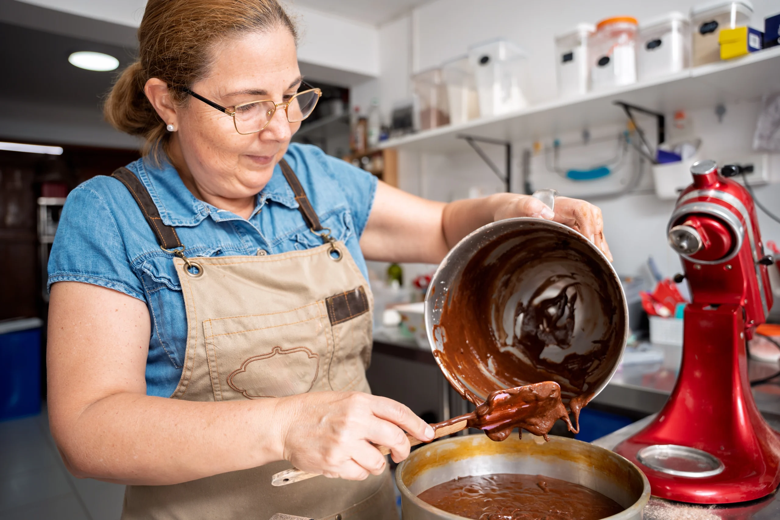 Molly Hart standing at her kitchen counter with students, teaching a hands-on baking class.