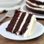 Chocolate cake with cream cheese frosting sliced and served on a plate